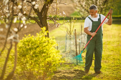 Workers managing garden waste and site safety controls